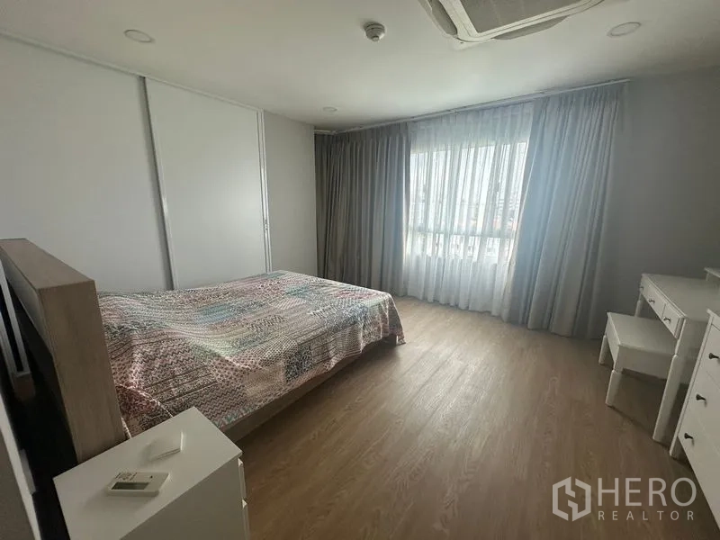 คอนโด ให้เช่า - ห้องนอนกว้างพร้อมหน้าต่างบานใหญ่ ผ้าม่านพื้นจรดเพดาน พื้นไม้ และเตียงควีน