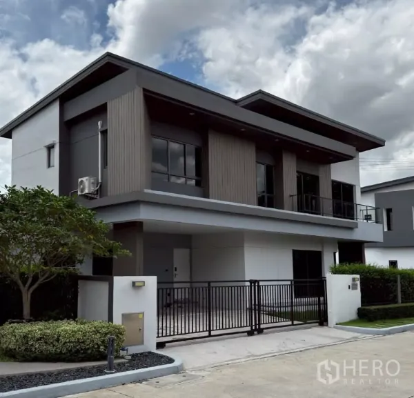 独立式住宅 出租或出售在Lat Krabang, Bangkok - 斜角拍摄的两层现代住宅，黑色金属大门、带顶车位与简洁外立面。
