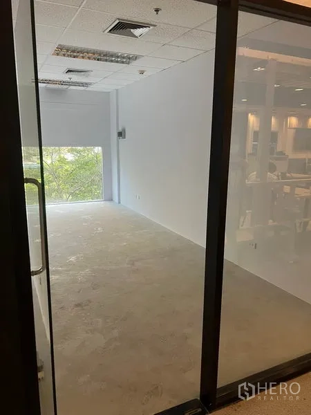 零售空间 出租在Bang Rak, Bangkok - 透过玻璃门看到狭长店铺，尽端采光窗与天花空调出风口。