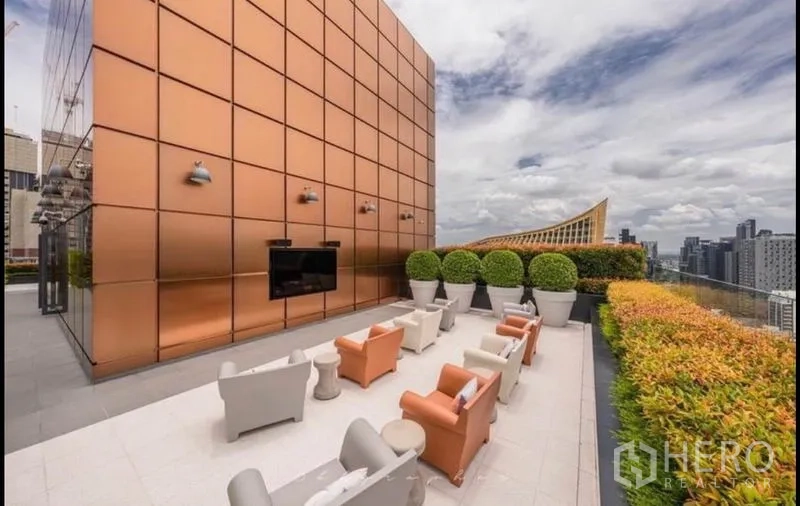 Condominium for rent or sale in Watthana, Bangkok - Rooftop terrace seating beside a copper-clad facade and outdoor TV.