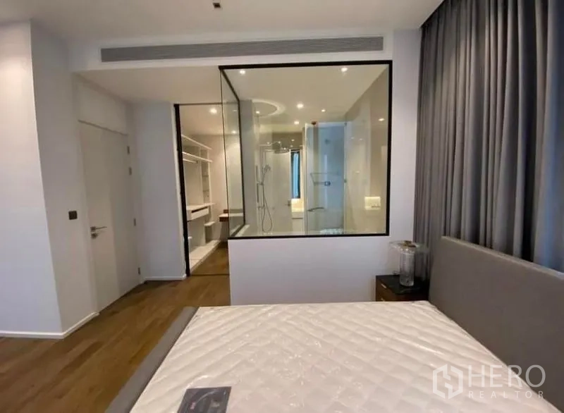 คอนโด ให้เช่าในPathum Wan, Bangkok - ห้องนอนหลักมองเห็นห้องน้ำในตัวผนังกระจกและวอล์กอินโคลเซ็ตจากปลายเตียง