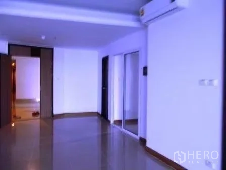 公寓 出租在Bangkok - 开放式走廊与起居区，配空调与镜面衣柜，现代公寓内部。