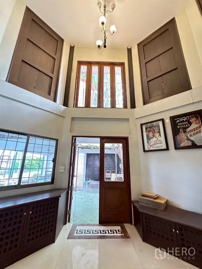 Home Office for rent in Lat Phrao, Bangkok - Double-height entry hall with wooden doors, clerestory windows and a chandelier