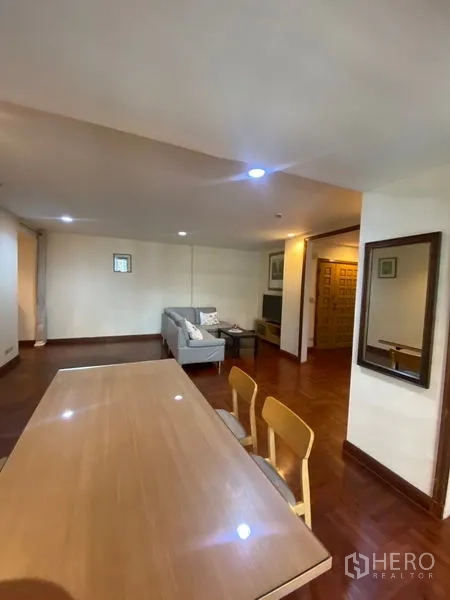 公寓 出租在Pathum Wan, Bangkok - 开放式客餐空间通向入户门，木地板与嵌灯。