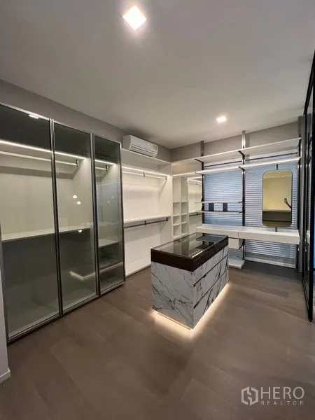Detached House for sale in Saphan Sung, Bangkok - Large walk-in closet with glass wardrobes, center island and vanity desk.