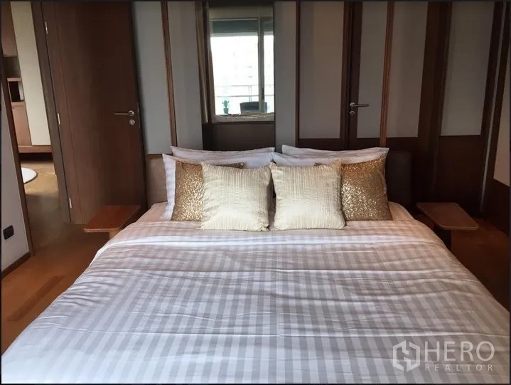 คอนโด ให้เช่าในWatthana, Bangkok - ห้องนอนหลักพร้อมเตียงบุนวม โทนไม้ และตู้เสื้อผ้า