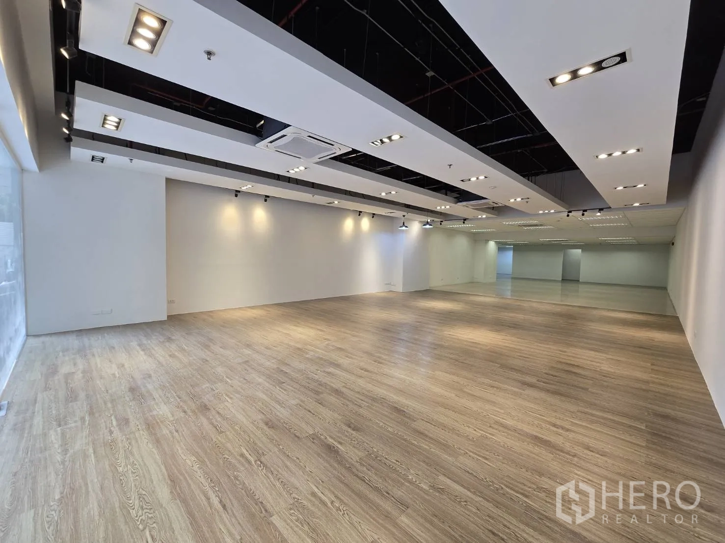 พื้นที่ขายของ for rent in Watthana, Bangkok - โชว์รูมกว้างพื้นลายไม้ พร้อมไฟสปอตไลท์บนราง