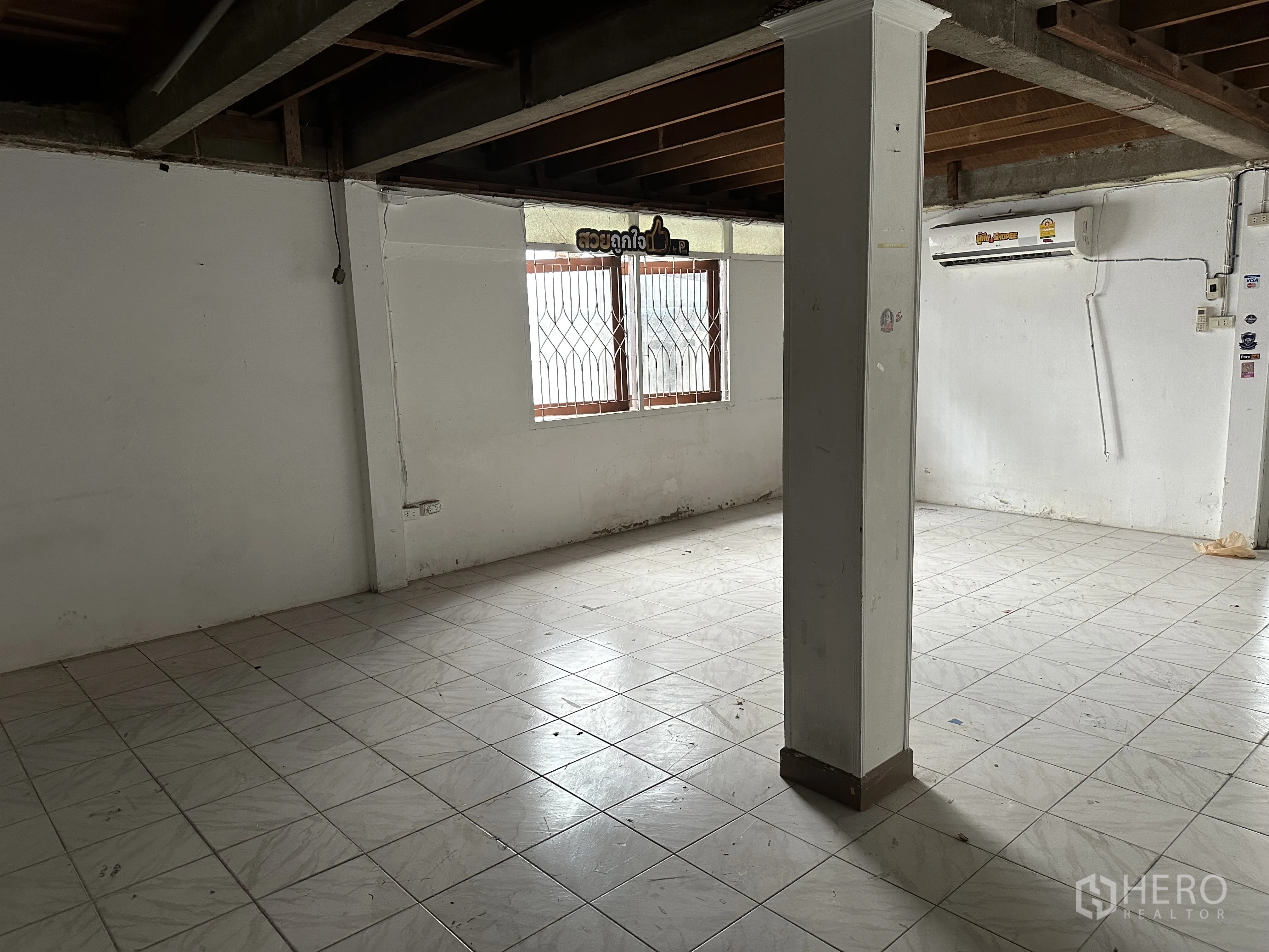 家庭办公室 for rent in Suan Luang, Bangkok - 底楼开放空间，瓷砖地面、立柱与带护栏窗户。
