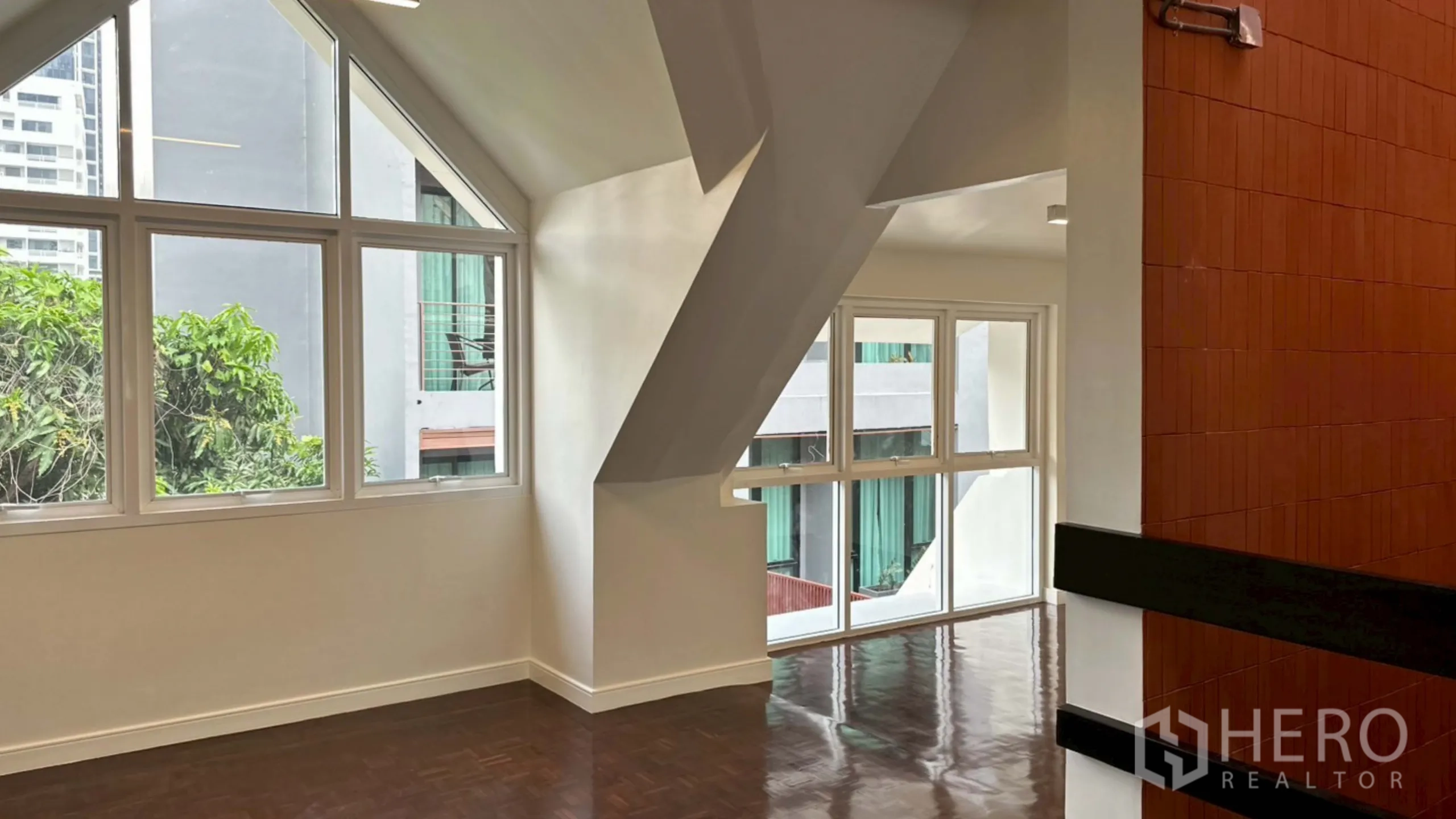 Home Office for rent in Watthana, Bangkok - Light-filled room with angular beams and large corner windows.