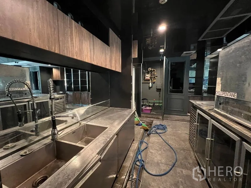 Retail Space for rent - Commercial back-of-house with stainless steel sinks, counters and under-counter fridges.