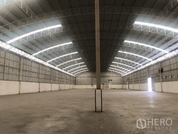 Warehouse for rent in Bang Pa-in, Phra Nakhon Si Ayutthaya - Clear-span central aisle inside the warehouse with skylights and concrete flooring.