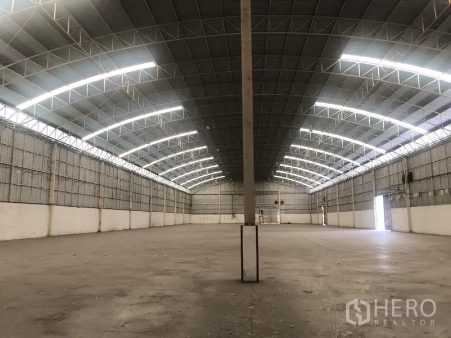 Warehouse for rent in Bang Pa-in, Phra Nakhon Si Ayutthaya - Clear-span central aisle inside the warehouse with skylights and concrete flooring.