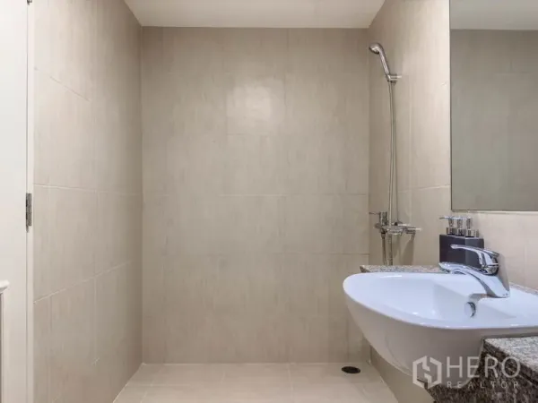 公寓 出售在Watthana, Bangkok - 通罗公寓内，浅色瓷砖浴室，墙挂式花洒与洗手台