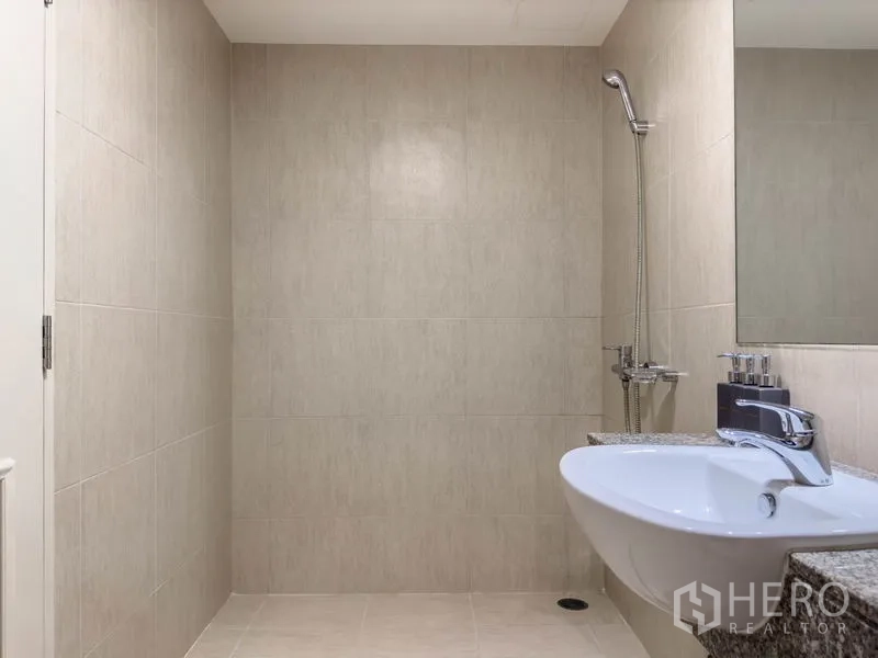 公寓 出售在Watthana, Bangkok - 通罗公寓内，浅色瓷砖浴室，墙挂式花洒与洗手台
