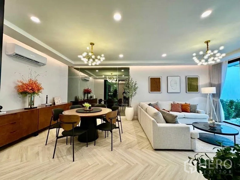 独立式住宅 出租在Bang Phli, Samut Prakan - 开放式客餐厅，鱼骨拼地板与双吊灯。