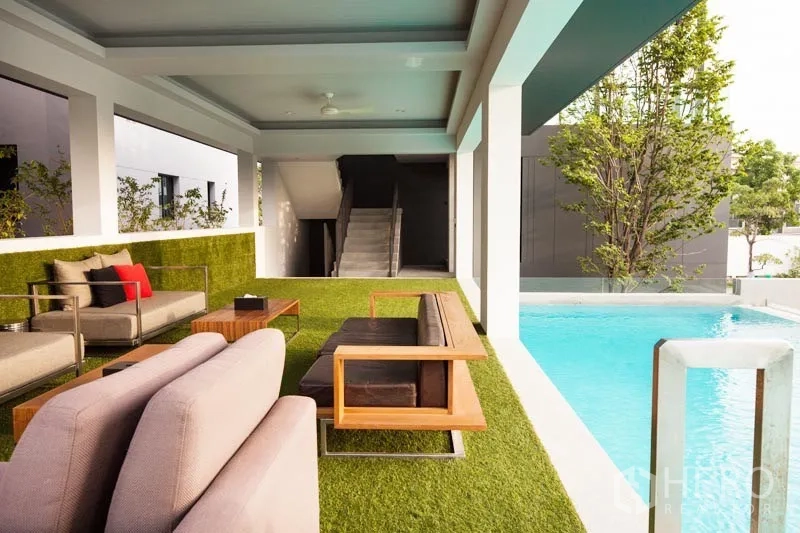 Detached House for rent or sale in Bang Kapi, Bangkok - Covered lounge beside community swimming pool with modern outdoor seating.
