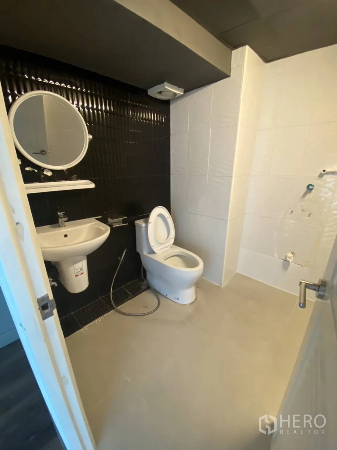 Retail Space for rent in Huai Khwang, Bangkok - Clean restroom with toilet, basin and contrasting black-and-white tiles.