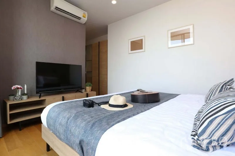 公寓 出售在Bang Rak, Bangkok - 次卧配电视柜、空调与舒适床铺。