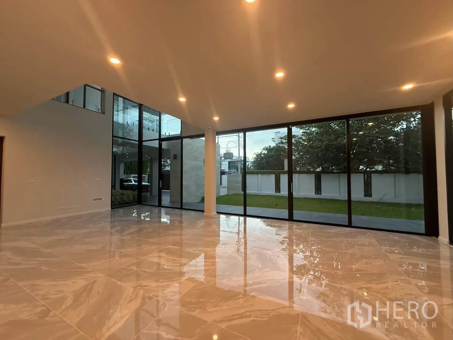 บ้านเดี่ยว for rent in Bang Khen, Bangkok - พื้นที่นั่งเล่นโอเพนแพลน ผนังกระจกสูงและพื้นกระเบื้องเงางาม