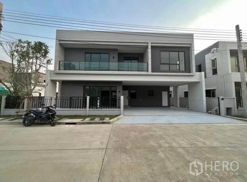 บ้าน ให้เช่าในBang Phli, Samut Prakan - บ้านเดี่ยวสองชั้นสไตล์โมเดิร์นในบางพลี พร้อมระเบียงกระจก รั้วรอบ และที่จอดรถคู่กว้างขวาง
