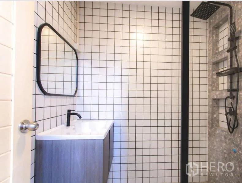 Detached House for sale in Wang Thonglang, Bangkok - Second bathroom featuring grid-pattern wall tiles, walk-in shower and a modern vanity.