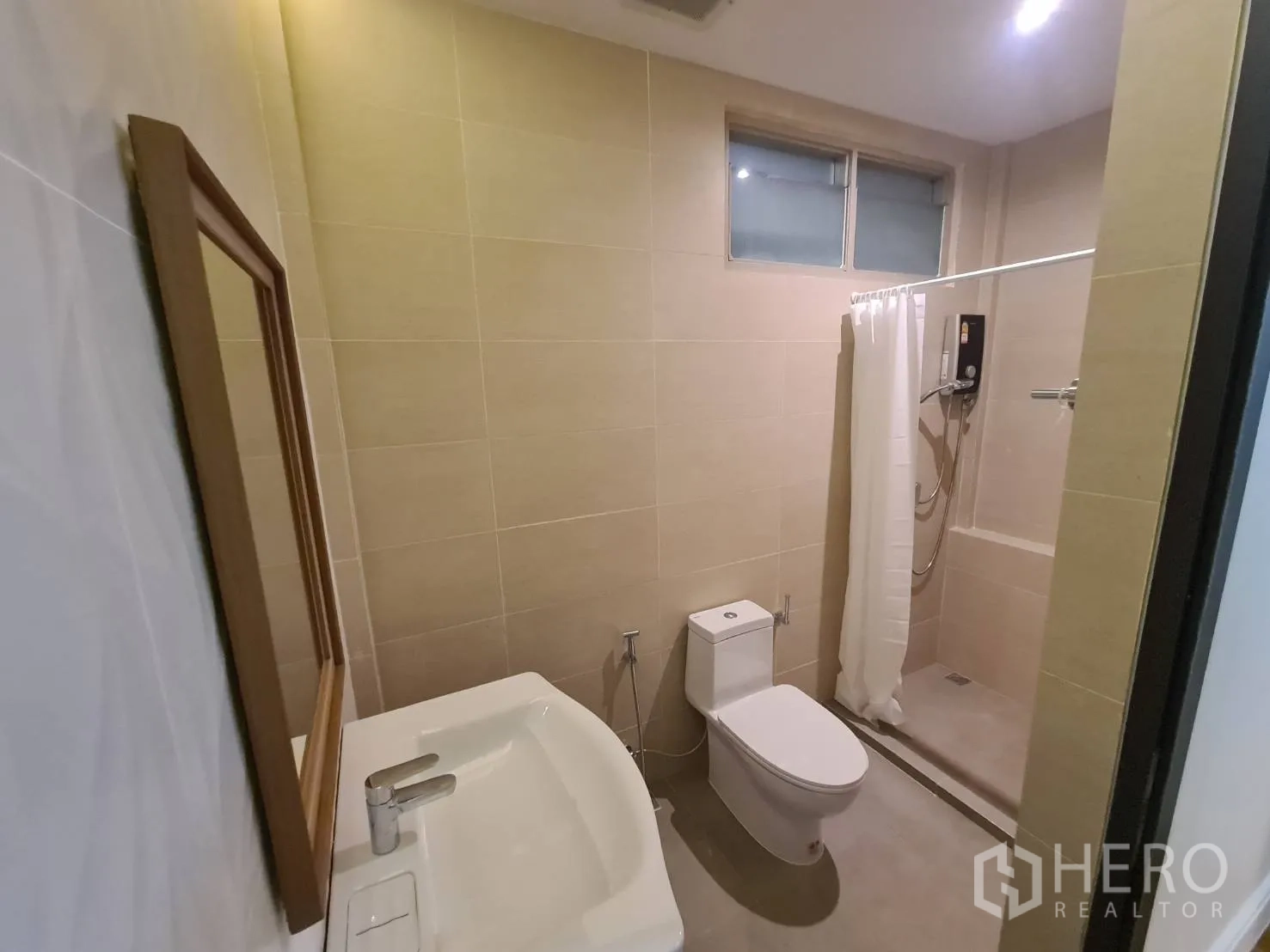 Detached House for rent in Khlong Toei, Bangkok - Bathroom with shower area, vanity and warm beige tiles.