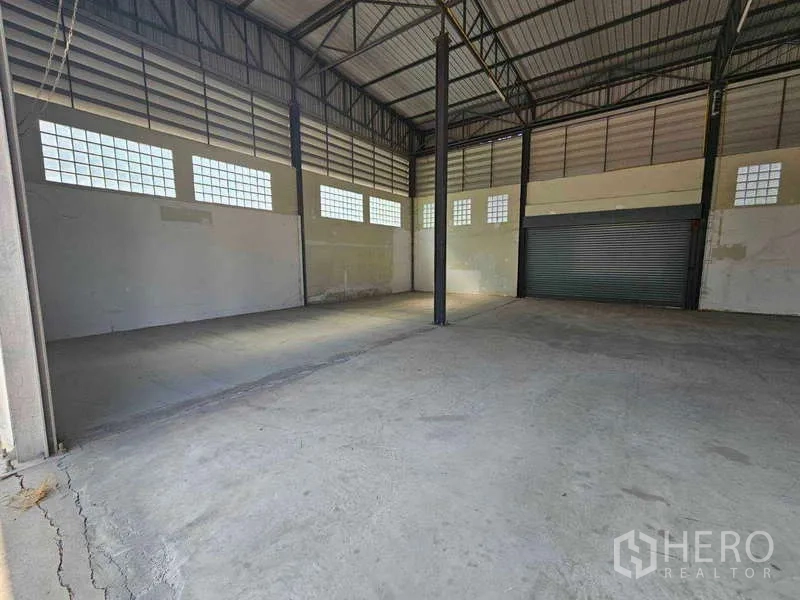 คลังสินค้า ให้เช่าในBang Bua Thong, Nonthaburi - ภายในโกดังเพดานสูง โครงหลังคาเหล็ก พื้นคอนกรีต หน้าต่างบล็อกแก้ว และประตูม้วน
