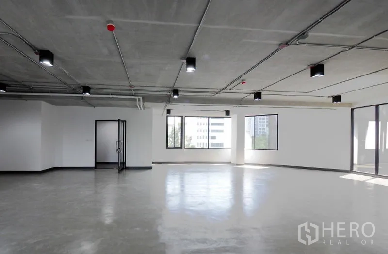 Office Space for rent in Khlong Toei, Bangkok - Bright open-plan office with polished concrete floors, exposed ceiling lighting, large windows and a glass entry door in Thonglor, Bangkok.