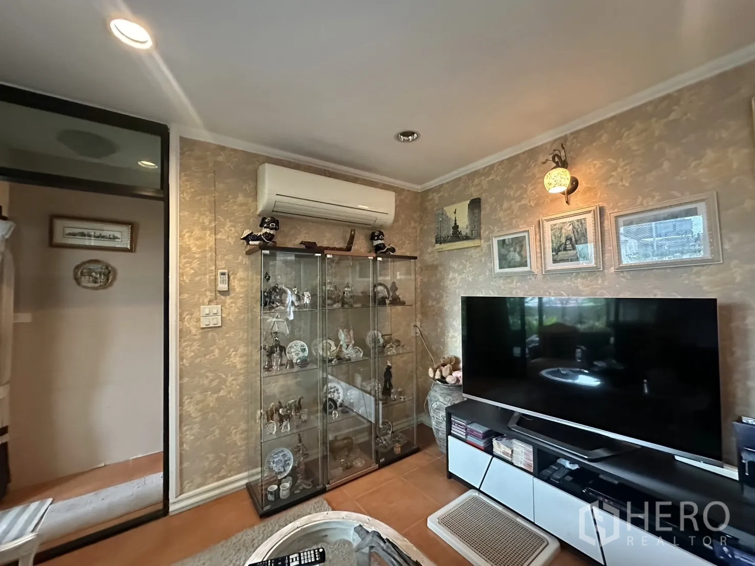 ตึกแถว for sale in Watthana, Bangkok - ห้องดูทีวีมีตู้โชว์กระจก ทีวีจอใหญ่ และงานศิลป์บนผนัง.