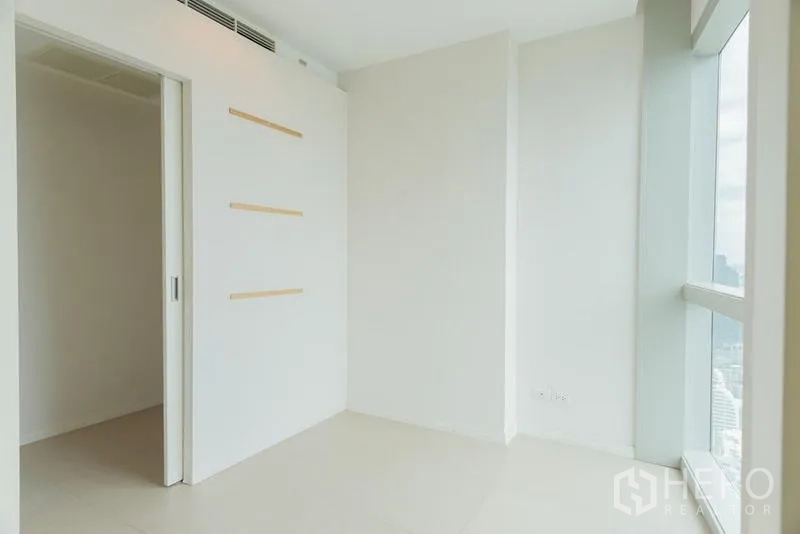 公寓 出售在Khlong San, Bangkok - 小房间带滑门与墙面置物条，旁有大窗。