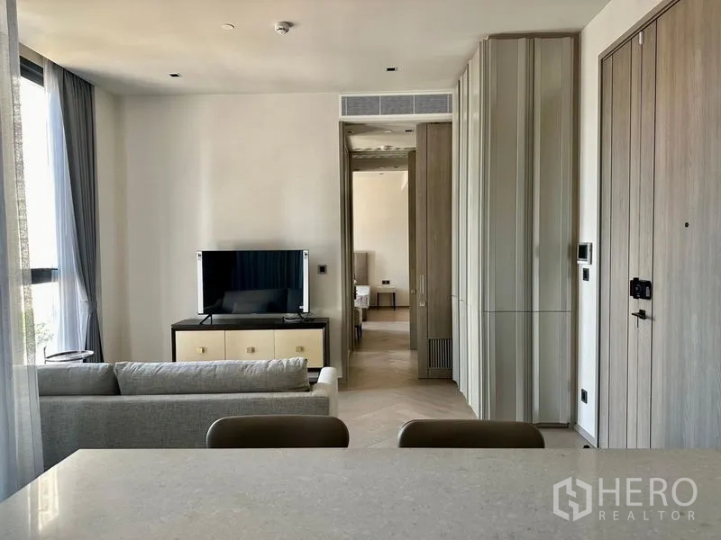Condominium for rent - View from kitchen to living area with TV unit and built-in storage.