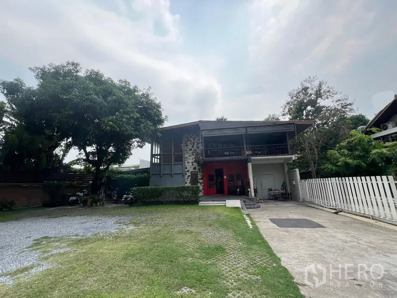 Detached House for rent in Khlong Toei, Bangkok - Two-storey detached house with stone feature wall, red doors, large lawn and driveway near Ekkamai BTS.
