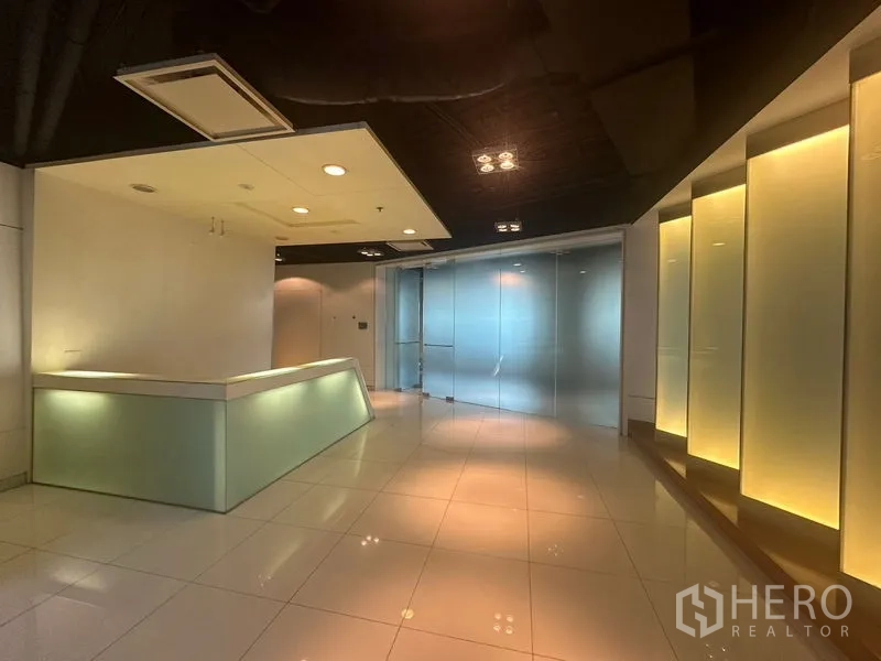 Office Space for rent in Khlong Toei, Bangkok - Modern reception with soft lighting, glossy tiles and a frosted glass door.
