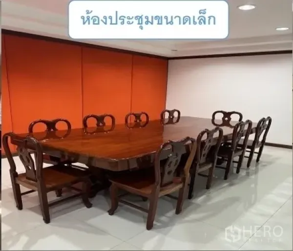 货栈 出租在Mueang Pathum Thani, Pathum Thani - 小型会议室，长木桌与复古椅，橙色背景墙