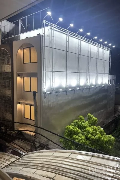 Shophouse for rent - Night exterior of a renovated 4.5‑storey shophouse with illuminated billboard frames near BTS Punnawithi in Phra Khanong, Bangkok.