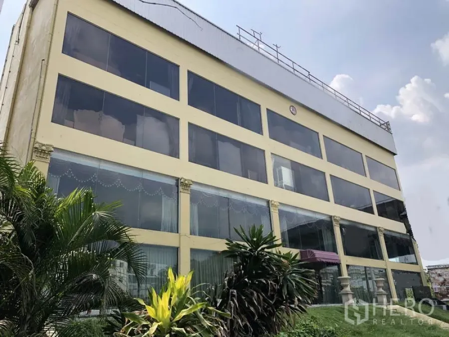 带办公室的家 出租或出售在Huai Khwang, Bangkok - 多层住宅办公楼外立面，整面玻璃窗与前方绿植，位于曼谷 Huai Khwang 区