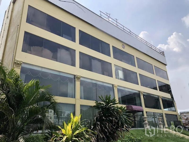 带办公室的家 出租或出售在Huai Khwang, Bangkok - 多层住宅办公楼外立面，整面玻璃窗与前方绿植，位于曼谷 Huai Khwang 区