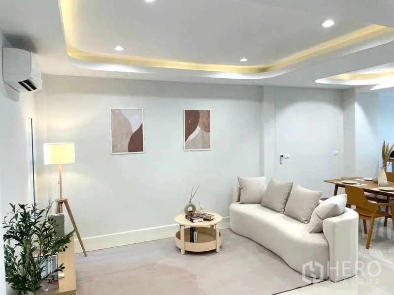 Townhouse for sale in Khlong Toei, Bangkok - Living room with cove lighting, air conditioning, modern sofa and view to dining.