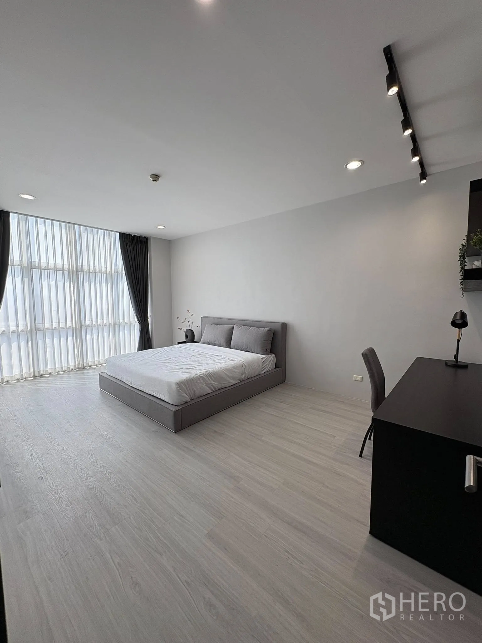 คอนโด for rent in Ratchathewi, Bangkok - ห้องนอนกว้างพร้อมโต๊ะทำงาน ไฟราง และพื้นไม้สีอ่อน