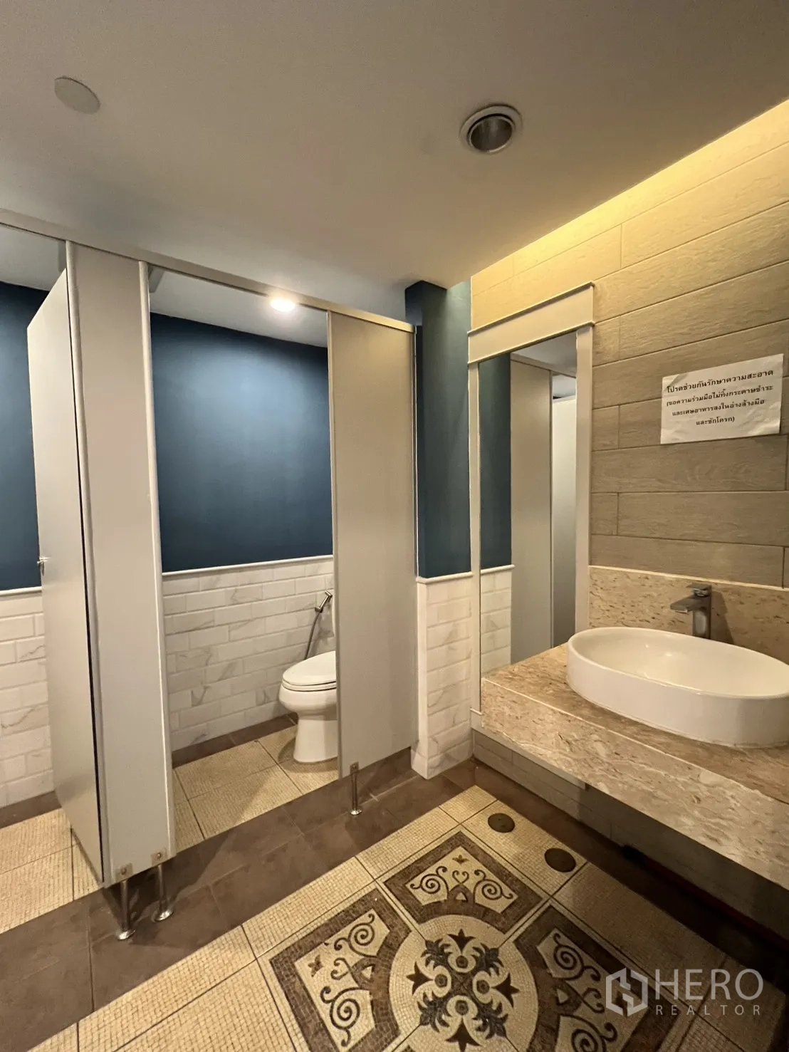 Office Space for rent in Watthana, Bangkok - Restroom with stalls, vessel sink, and patterned floor tiles.