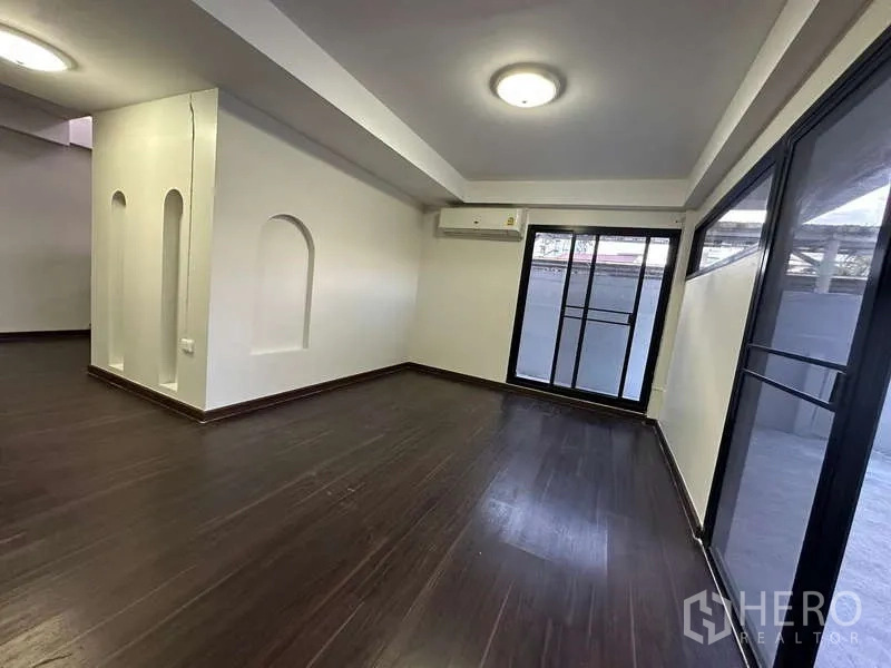 Home Office for rent in Din Daeng, Bangkok - Bright office living area with dark wood floors, wall niches and large windows with sliding door.