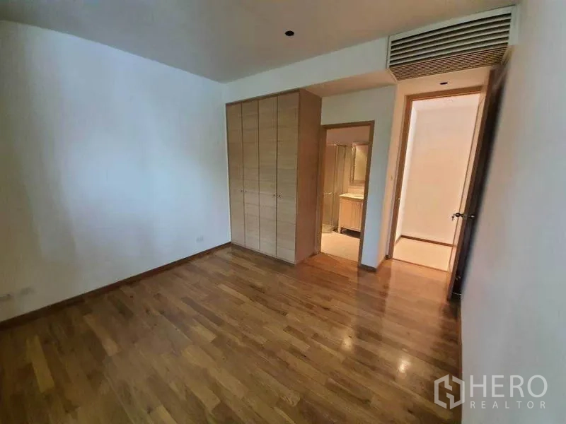 Condominium for rent or sale in Sathon, Bangkok - Bedroom featuring built-in wardrobe and entrance to an ensuite bathroom.