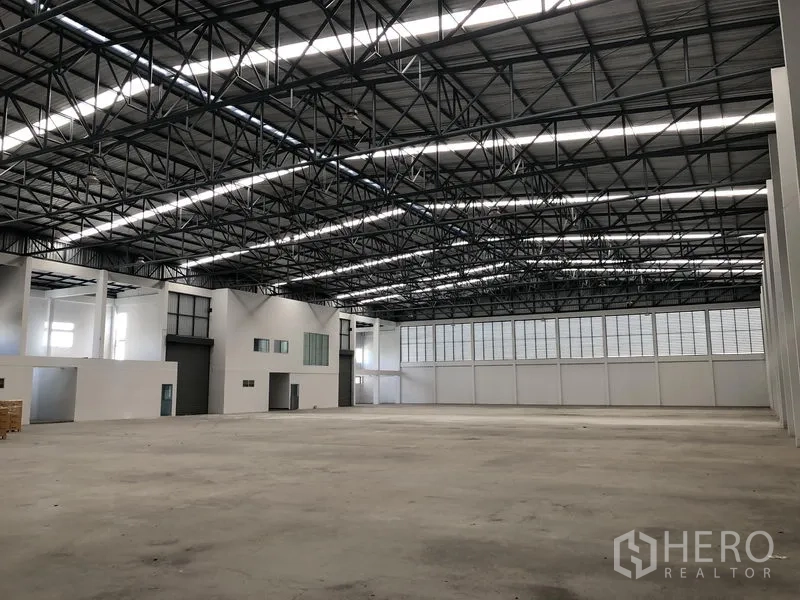 Factory for rent in Phra Nakhon Si Ayutthaya - Expansive empty production area showing steel trusses and skylights.