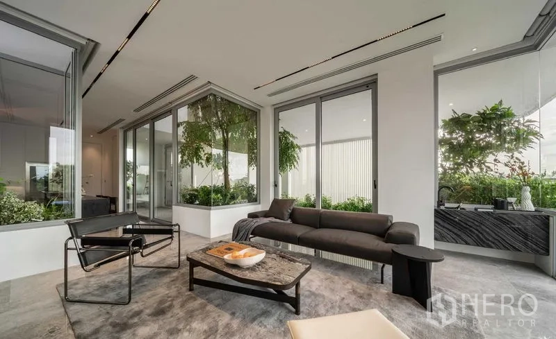 Detached House for sale in Saphan Sung, Bangkok - Minimal lounge with panoramic sliding doors and indoor planter garden.