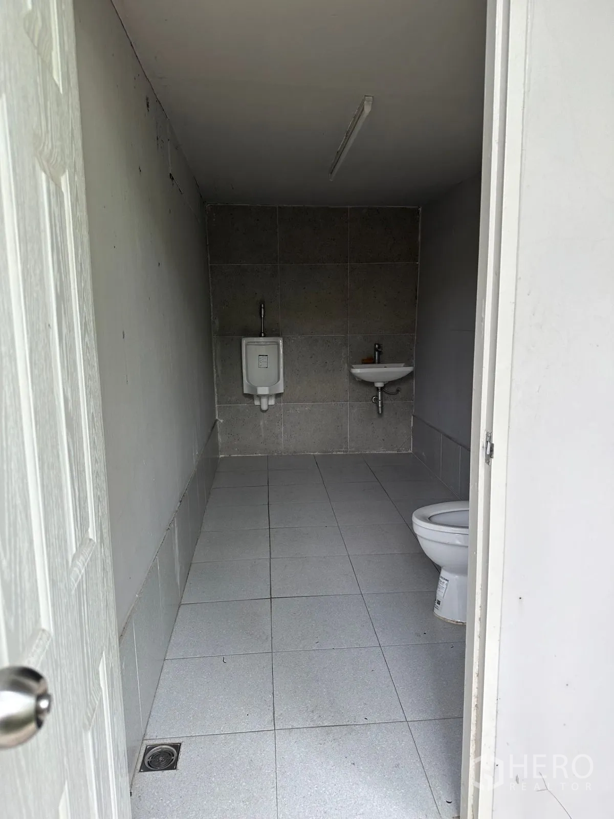 Home Office for rent in Chatuchak, Bangkok - Simple bathroom with toilet, urinal and tiled floor.