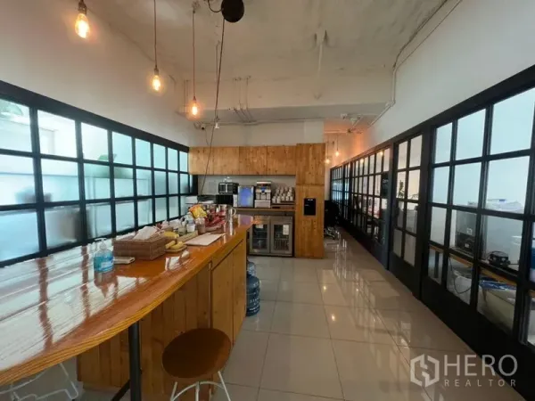สำนักงาน ให้เช่าในKhlong Toei, Bangkok - แพนทรีพร้อมเคาน์เตอร์ไม้เงา เก้าอี้สตูล ไฟห้อย ตู้เก็บของ และผนังกระจกฝ้า