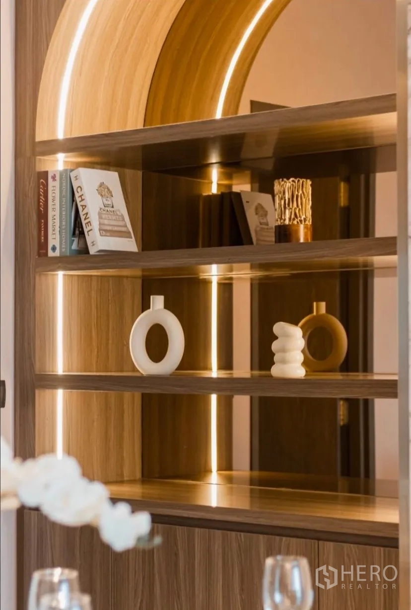 Condominium for rent in Watthana, Bangkok - Close-up of illuminated arched shelving with decorative objects.