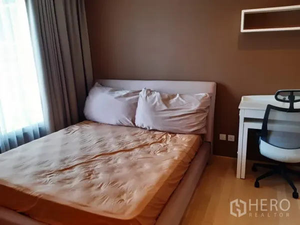 Condominium for rent in Khlong Toei, Bangkok - Cozy bedroom with double bed, sheer curtains and a study desk in warm tones.