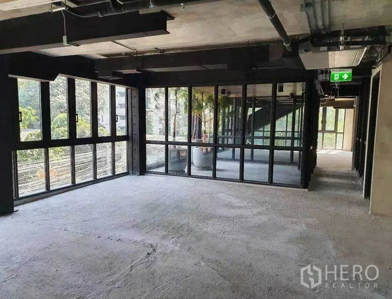 Retail Space for rent in Watthana, Bangkok - Bright retail floor with wraparound glazing near staircase core and aluminum-framed doors.