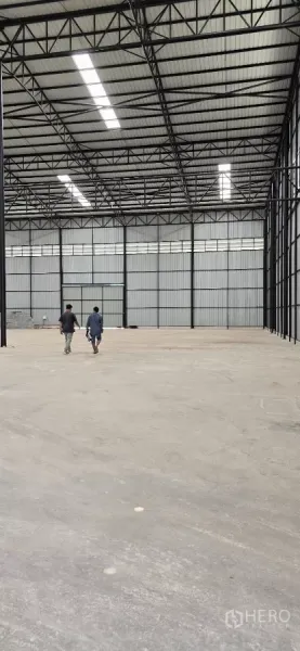 Factory for rent in Mueang Samut Sakhon, Samut Sakhon - Deep view across the open factory hall toward large access doors, showing expansive floor space.